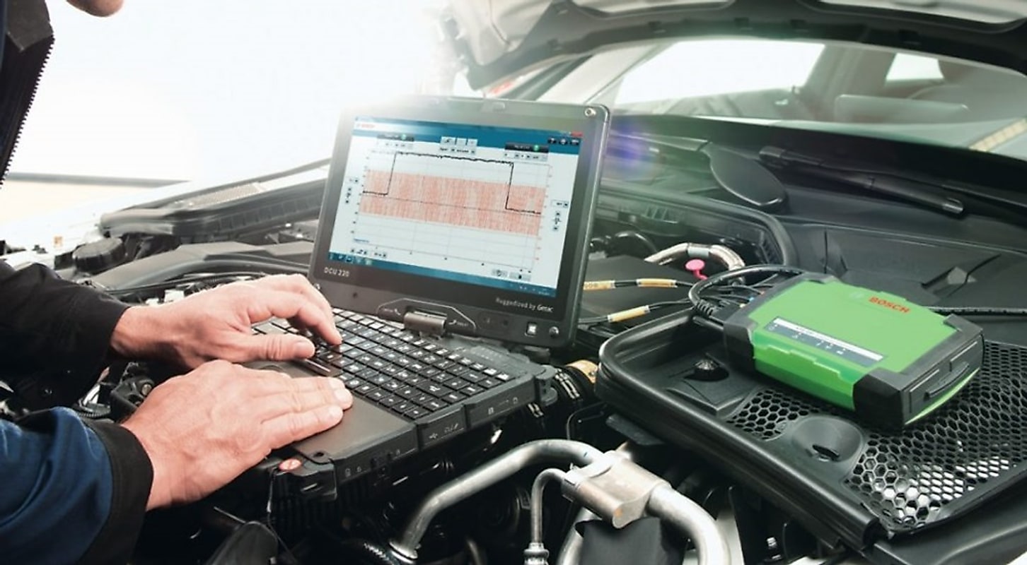 Un tecnico al lavoro con il tester di diagnosi collegato al vano motore.