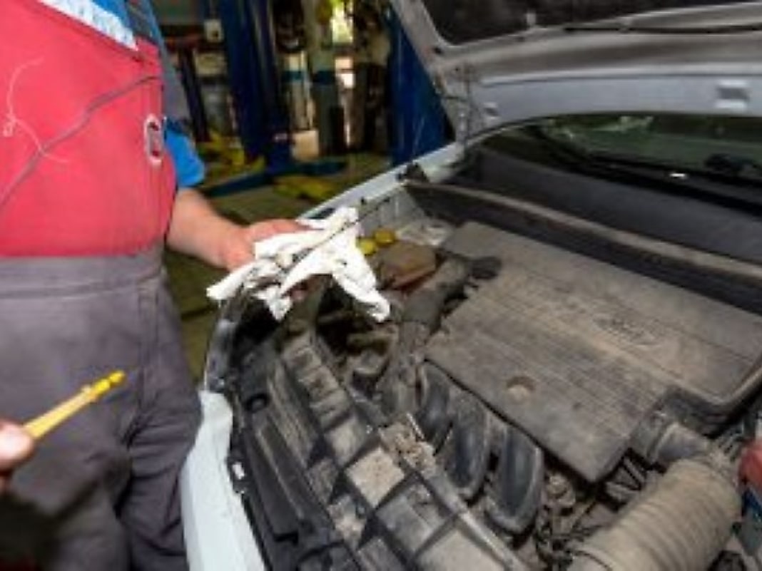 Un meccanico dell'officina al controllo sotto il cofano di una vettura.