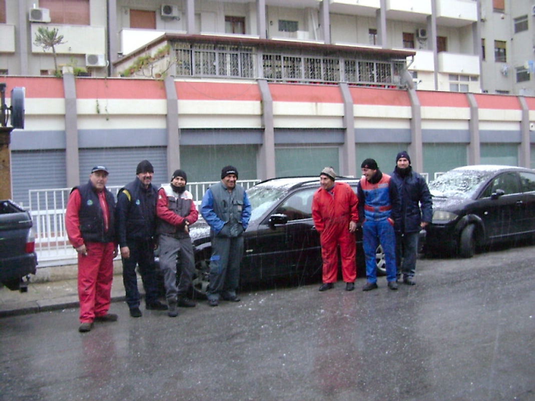 La squadra dell'officina davanti alla sede durante la nevicata.